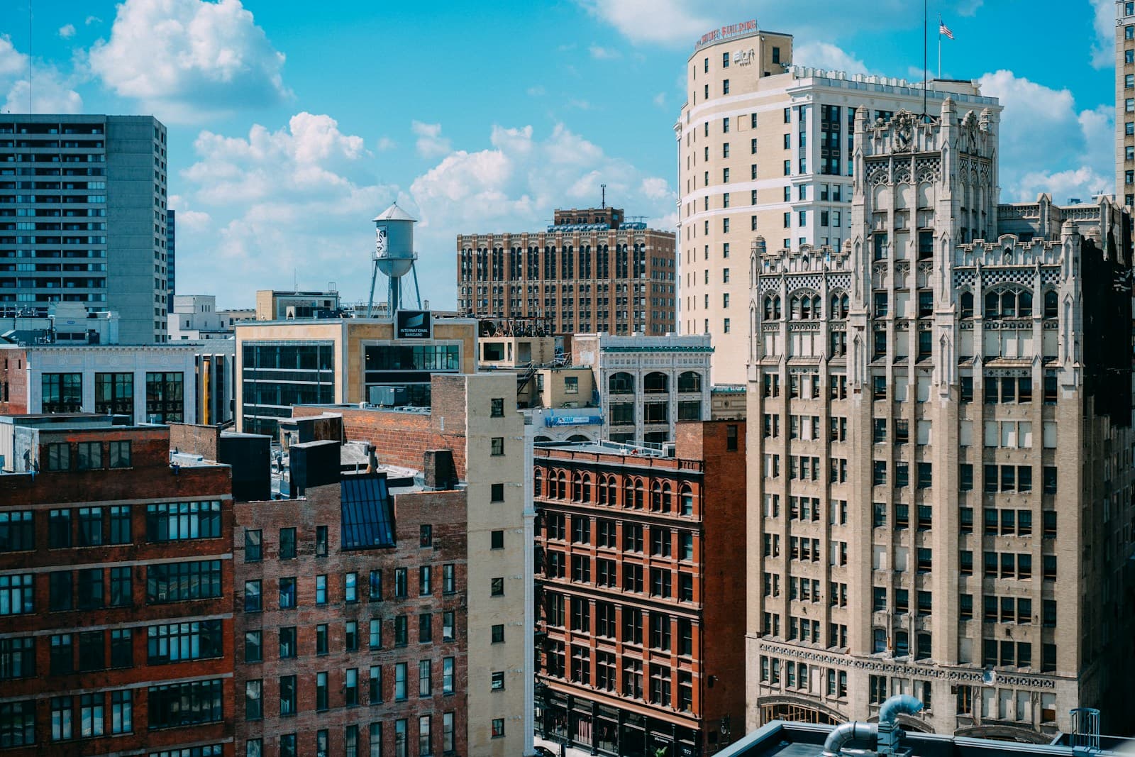 Downtown city skyline with mix of historic brick buildings and modern skyscrapers under blue sky